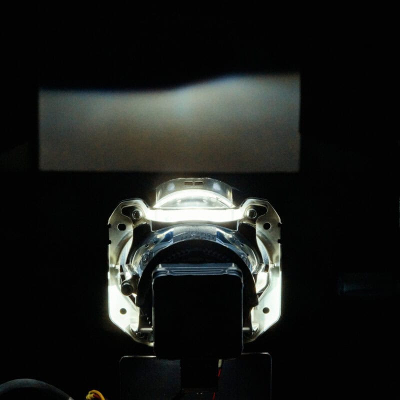 Illuminated optical glass component during photometric measurement in a darkroom.